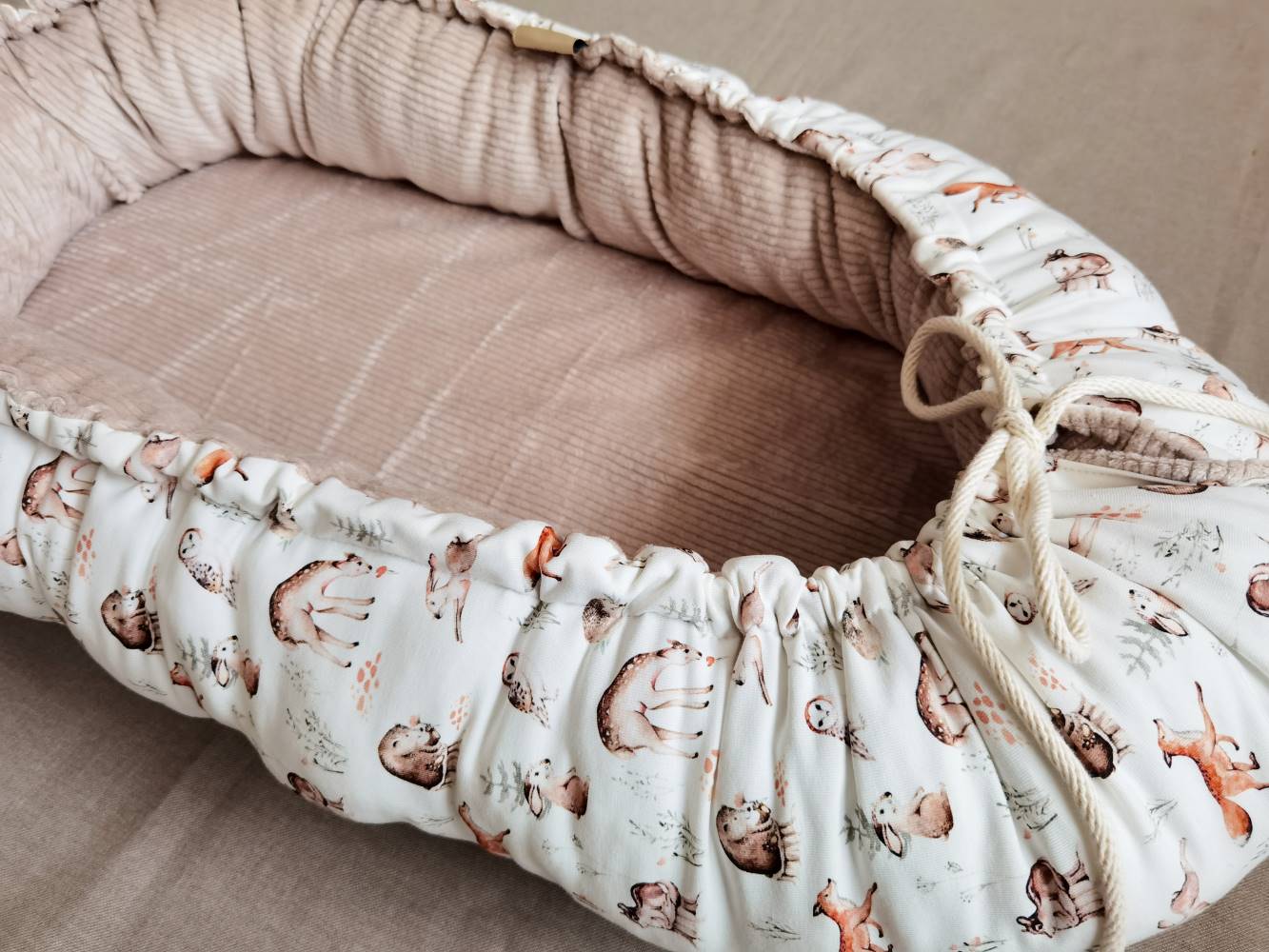 Selectionkreativ - seitliche Ansicht des Babynestchens mit beigen Cord und Jerseystoff mit Waldtiere