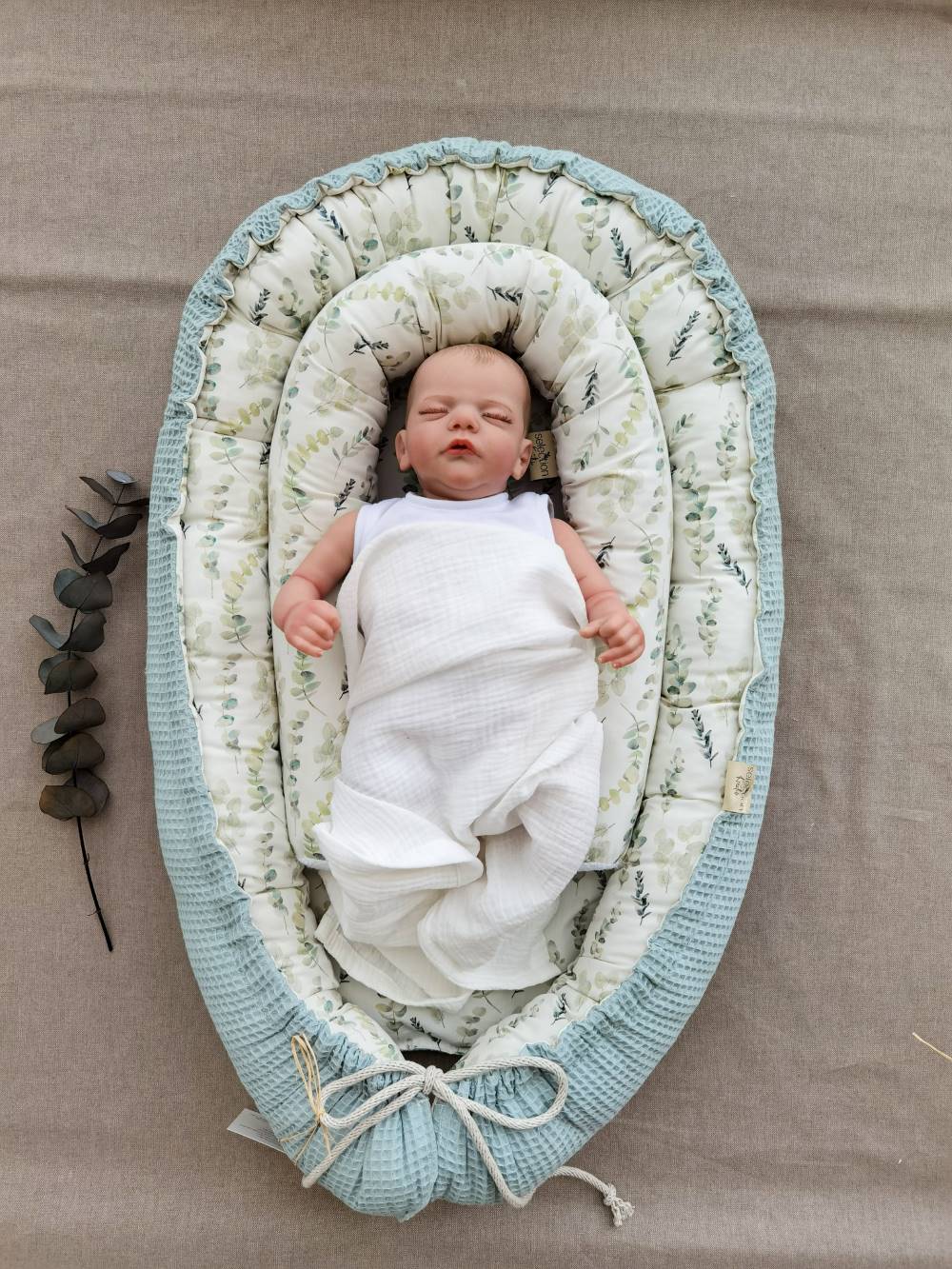 Selectionkreativ - Eukalyptus Zweige Babynest mit Baby liegend