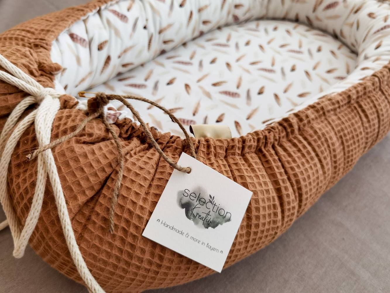 Selectionkrativ - Babynest mit Logo und Kordel in Ecruweiß