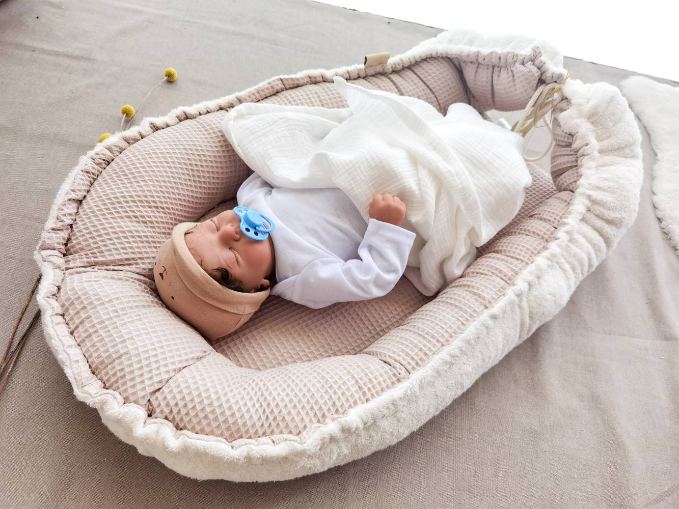 Selectionkreativ - Mit einer Kordel kann man das Babynest zusammen ziehen und eine Holzperle ist als Deko zu sehen.